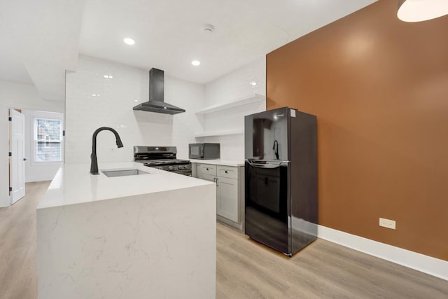 2134 W Shakespeare Ave, Chicago, IL 60647 - kitchen with a sink, wall chimney exhaust hood, baseboards, black appliances, and light wood-style floors