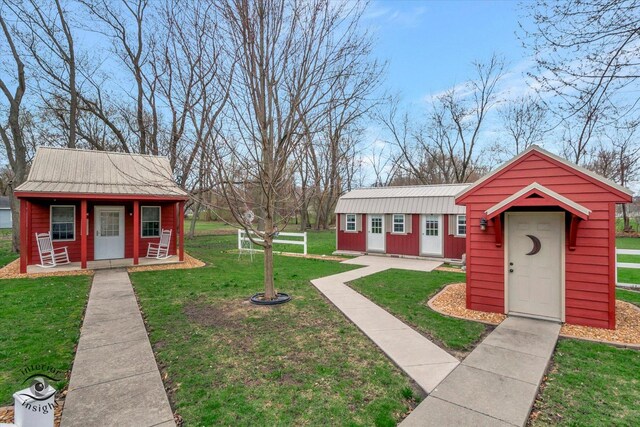 274 N School St, Braidwood, IL 60408 - view of front of house with an outbuilding, metal roof, covered porch, and a front lawn