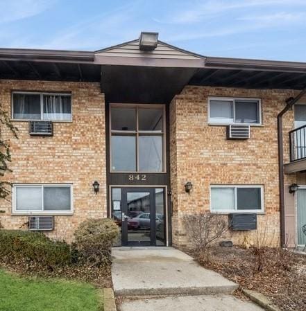 doorway to property featuring brick siding