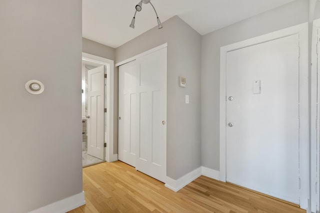 foyer with baseboards and light wood-type flooring