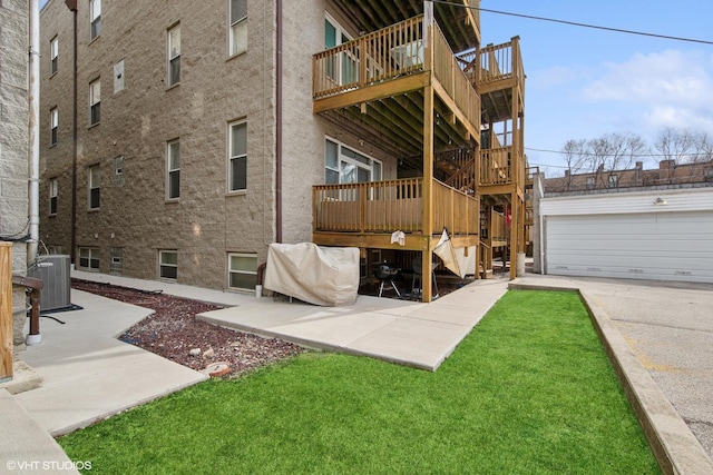 exterior space with a garage, an outbuilding, central AC, and a yard