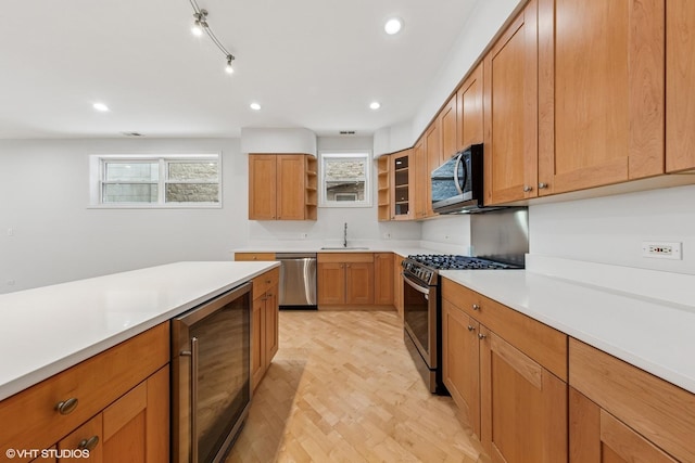 kitchen featuring light countertops, open shelves, stainless steel appliances, a sink, and beverage cooler