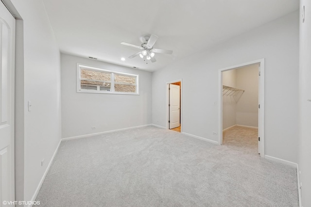 unfurnished bedroom with baseboards, carpet flooring, and a walk in closet