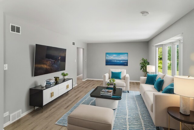 living room featuring baseboards, light wood-style flooring, and visible vents