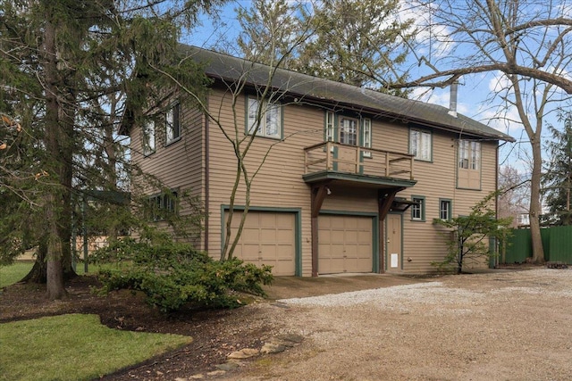 215 Prospect Ave, Highland Park, IL 60035 - view of front of house featuring an attached garage, dirt driveway, fence, and a balcony