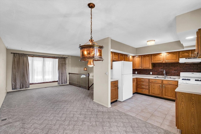 1618 Carolina Dr, Rantoul, IL 61866 - kitchen featuring light carpet, white appliances, under cabinet range hood, brown cabinetry, and a sink