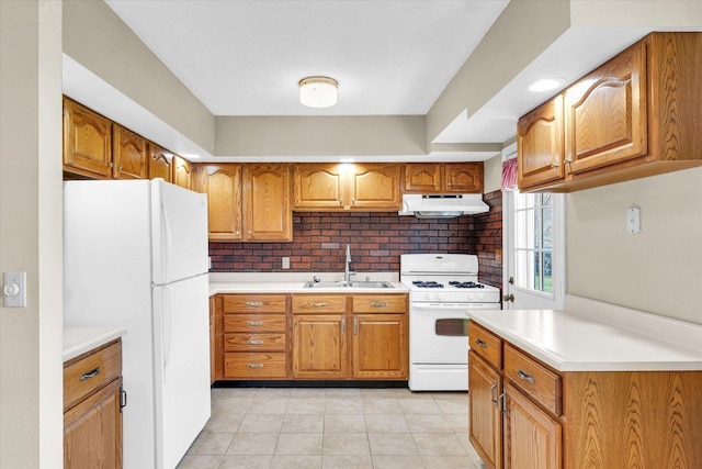 1618 Carolina Dr, Rantoul, IL 61866 - kitchen featuring brown cabinets, under cabinet range hood, a sink, and white appliances