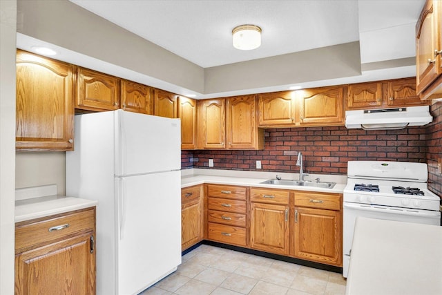 1618 Carolina Dr, Rantoul, IL 61866 - kitchen with white appliances, light countertops, under cabinet range hood, brown cabinetry, and a sink