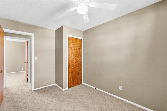 1618 Carolina Dr, Rantoul, IL 61866 - unfurnished bedroom featuring light colored carpet, baseboards, a ceiling fan, and a textured ceiling