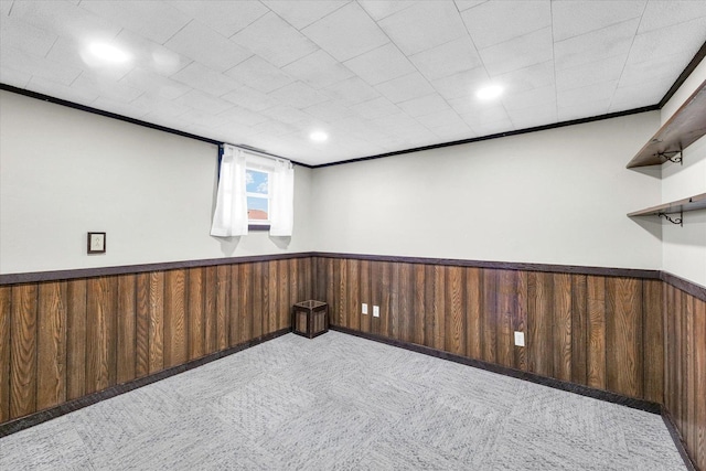 1618 Carolina Dr, Rantoul, IL 61866 - carpeted empty room featuring wooden walls, ornamental molding, and a wainscoted wall