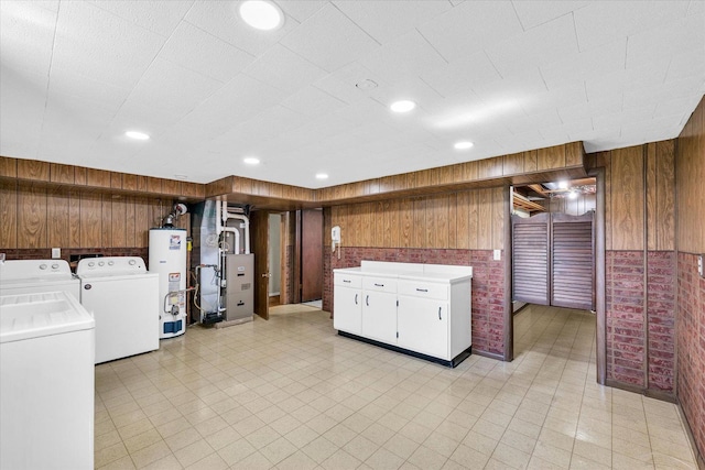 1618 Carolina Dr, Rantoul, IL 61866 - kitchen featuring washer and dryer, light countertops, heating unit, wood walls, and gas water heater