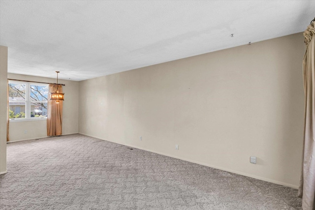 1618 Carolina Dr, Rantoul, IL 61866 - spare room with a chandelier, a textured ceiling, light colored carpet, and baseboards