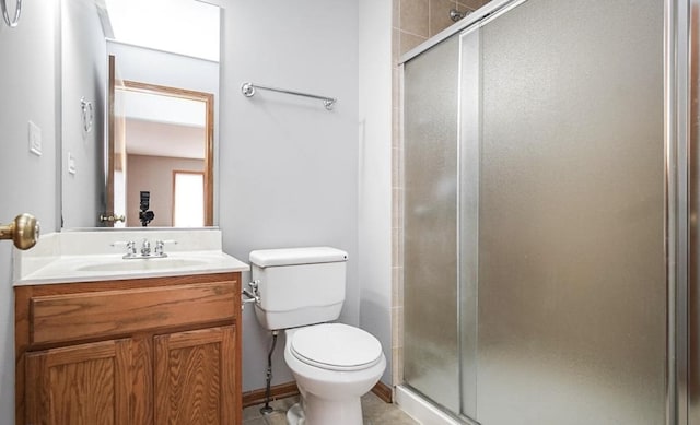 bathroom with a stall shower, toilet, and vanity