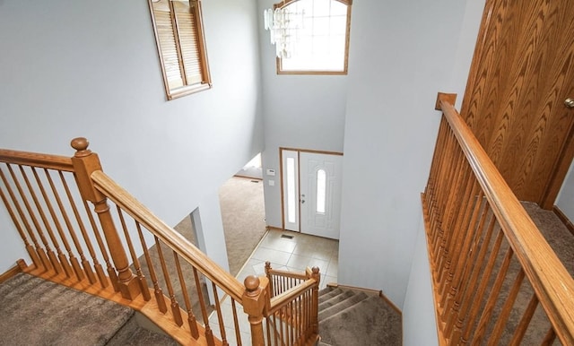carpeted entrance foyer with baseboards and a chandelier