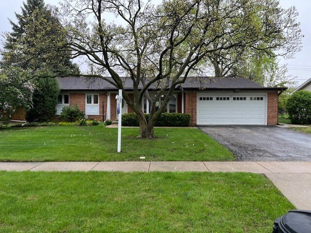 single story home with brick siding, an attached garage, a front lawn, and aphalt driveway