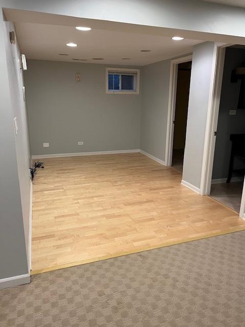 finished below grade area featuring recessed lighting, baseboards, and light wood-type flooring