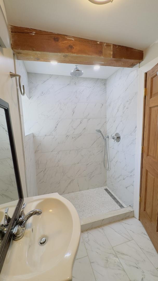 1745 W Cornelia Ave, Chicago, IL 60657 - bathroom featuring a marble finish shower and marble finish floors