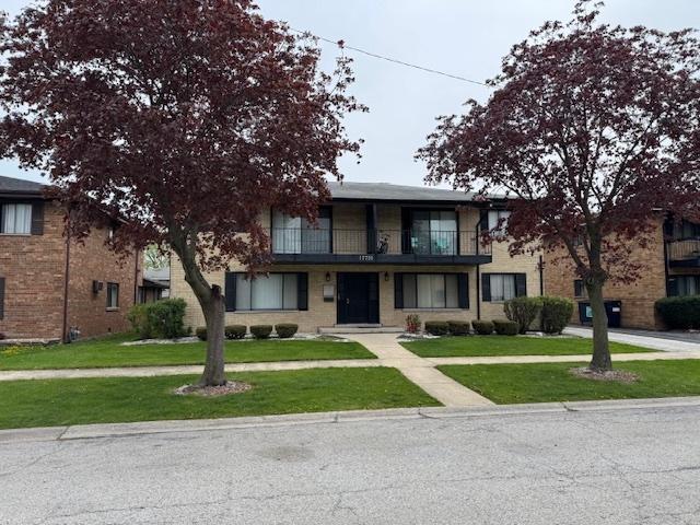 view of front of home with a front lawn and a balcony