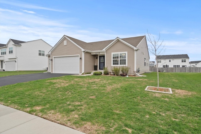 single story home with a front lawn, fence, an attached garage, and aphalt driveway