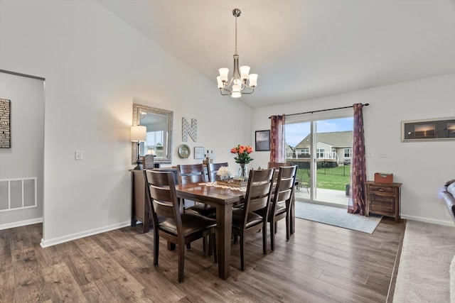 dining area with lofted ceiling, baseboards, visible vents, a notable chandelier, and wood finished floors