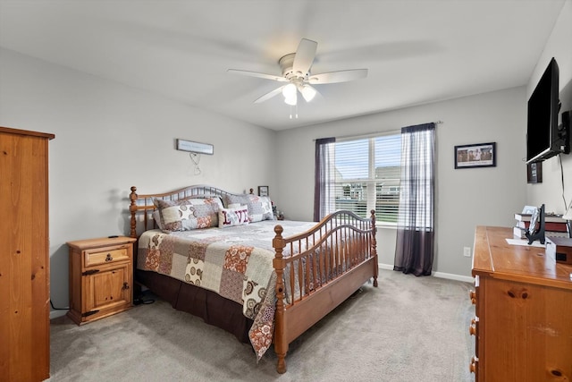 bedroom featuring light colored carpet, ceiling fan, and baseboards