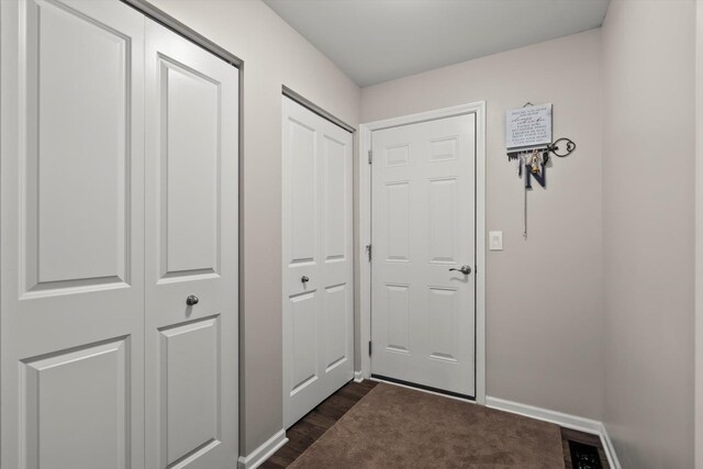 entryway with baseboards and dark wood-style floors