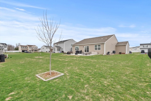 back of property with a lawn, a residential view, and a patio area