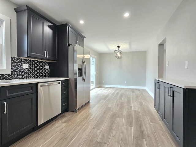 919 Dartmouth Ave, Matteson, IL 60443 - kitchen with decorative backsplash, light countertops, baseboards, appliances with stainless steel finishes, and light wood-type flooring