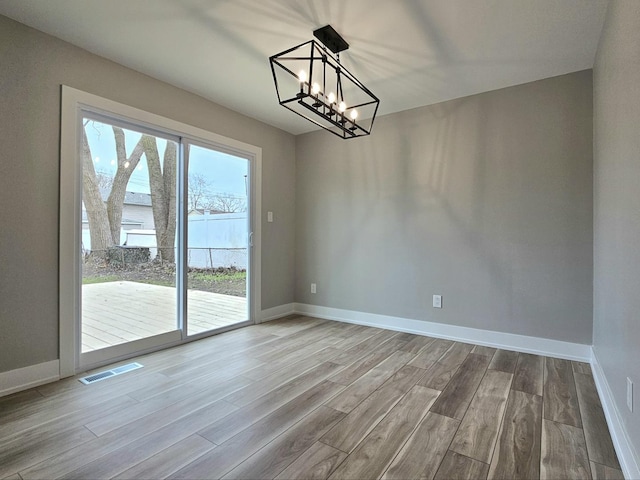 919 Dartmouth Ave, Matteson, IL 60443 - unfurnished dining area with wood finished floors, baseboards, a chandelier, and visible vents