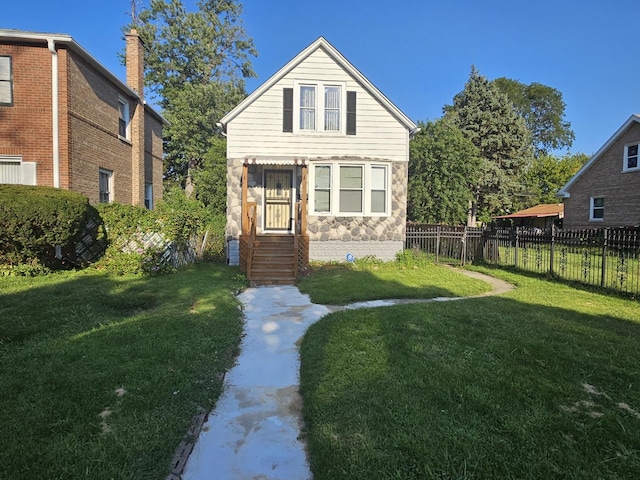 bungalow with stone siding, a front yard, and fence
