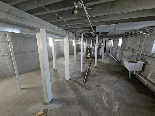 below grade area featuring water heater and a sink