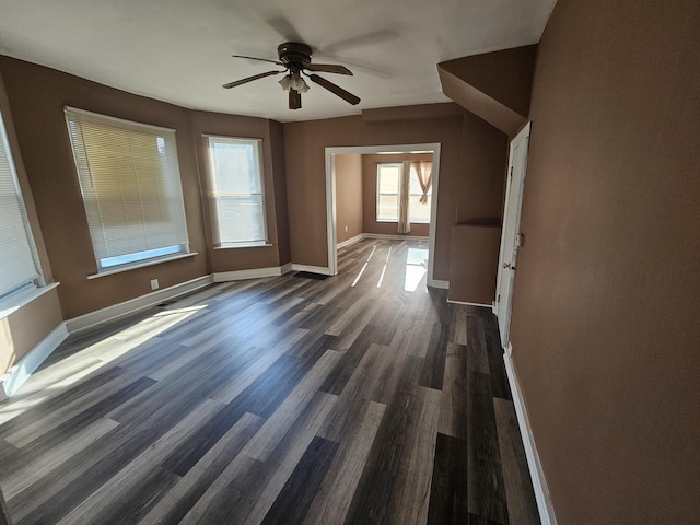 interior space featuring baseboards, ceiling fan, and dark wood finished floors