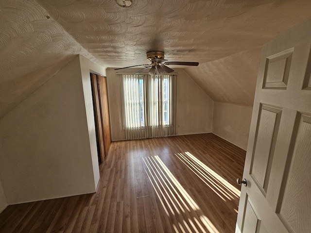 bonus room featuring a textured ceiling, ceiling fan, wood finished floors, and vaulted ceiling