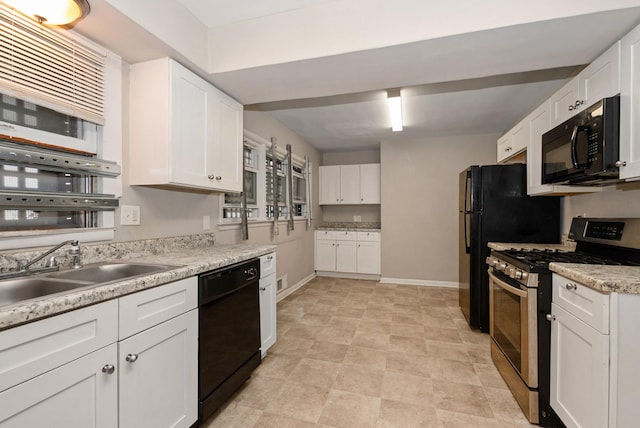 674 Memorial Dr, Calumet City, IL 60409 - kitchen with light countertops, a sink, white cabinetry, and black appliances