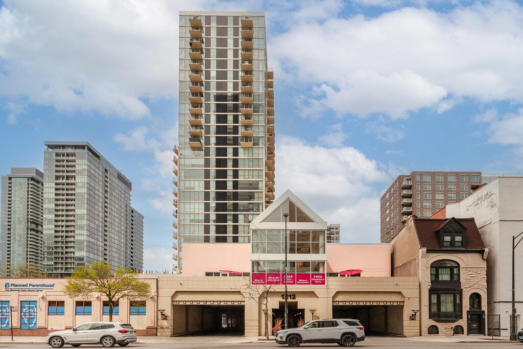 view of building exterior with an attached garage, a city view, and driveway