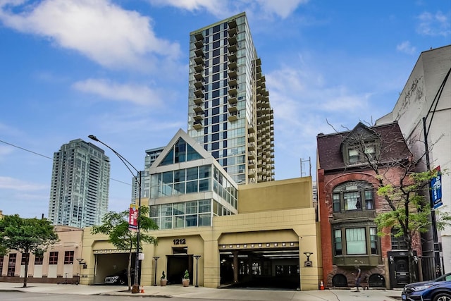 view of building exterior with an attached garage, a city view, and driveway