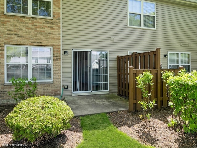 back of house with brick siding and a patio area