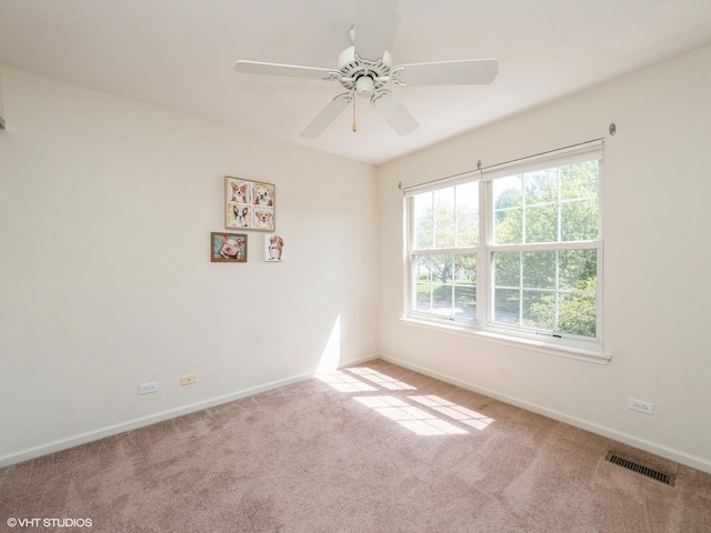 spare room with healthy amount of natural light, carpet floors, and baseboards