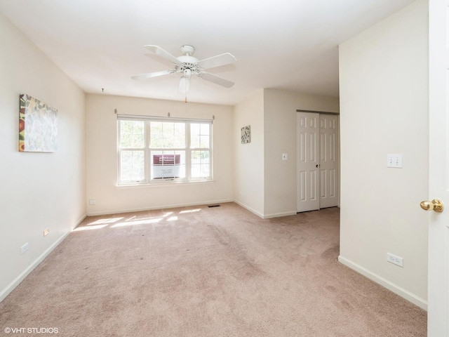 spare room featuring carpet flooring, ceiling fan, and baseboards