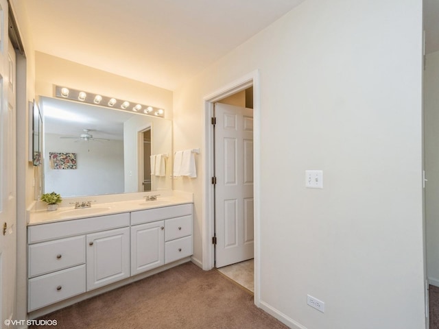 bathroom with double vanity, ceiling fan, and baseboards