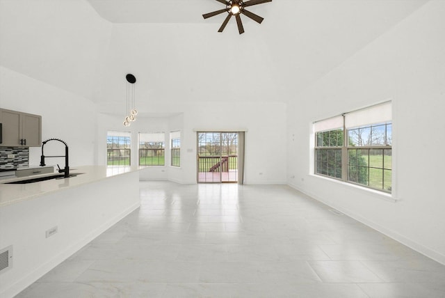 286 Sunset Blvd, Beecher, IL 60401 - unfurnished living room featuring a sink, high vaulted ceiling, a ceiling fan, and baseboards