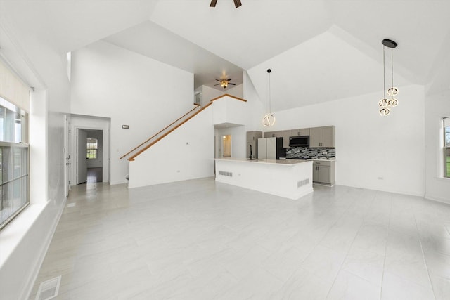 286 Sunset Blvd, Beecher, IL 60401 - unfurnished living room featuring high vaulted ceiling, a ceiling fan, and a healthy amount of sunlight