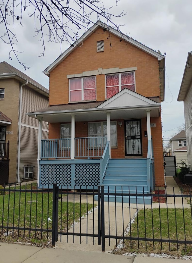 view of front of property with a porch, a front yard, and a fenced front yard