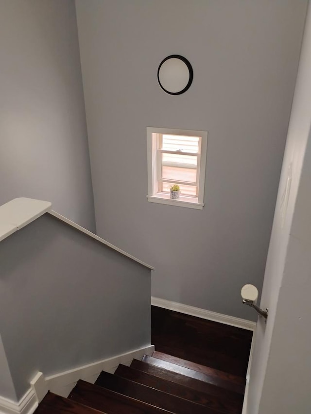 stairway with wood finished floors and baseboards