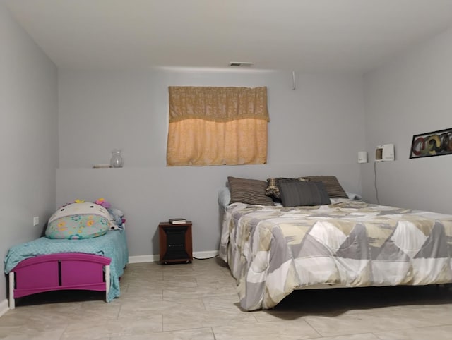 bedroom with baseboards and visible vents