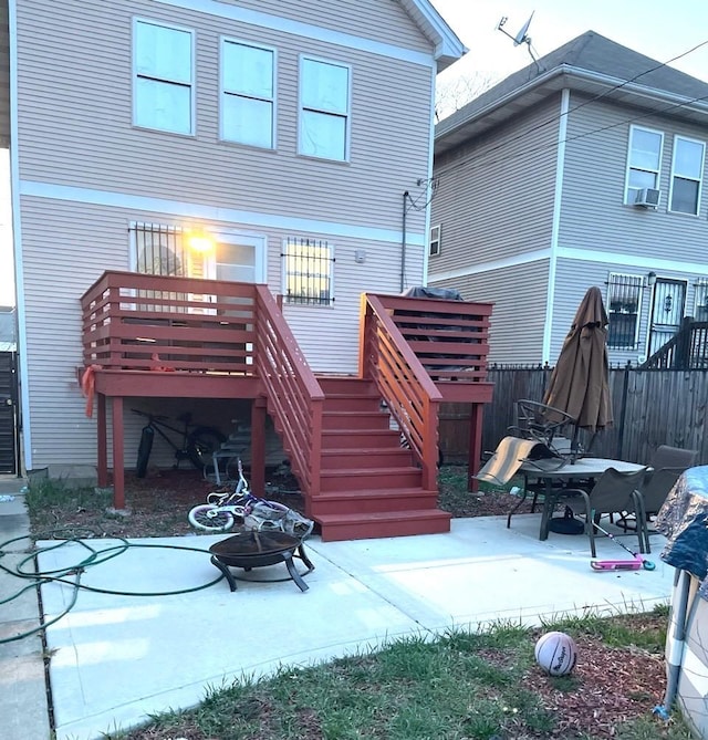 rear view of house featuring fence, stairs, a deck, a patio, and an outdoor fire pit