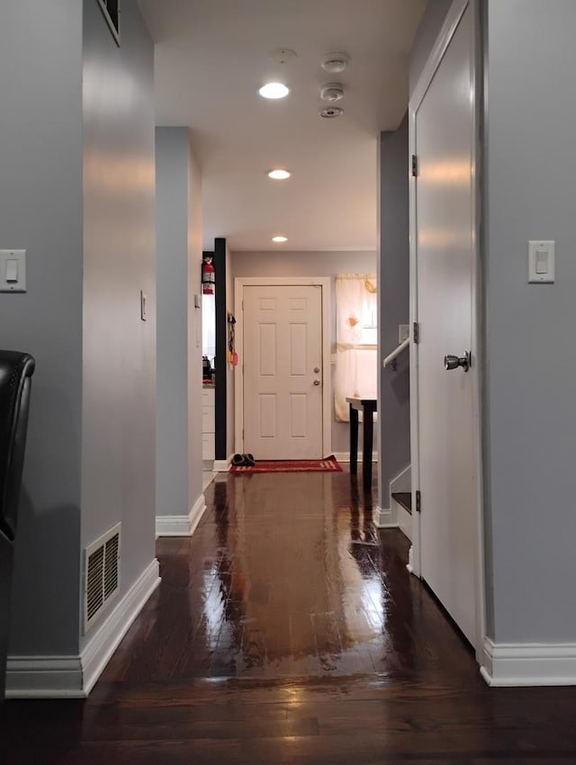 hallway with hardwood / wood-style floors, baseboards, visible vents, and recessed lighting