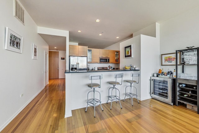 500 W Superior St Unit 1804, Chicago, IL 60654 - kitchen with stainless steel appliances, beverage cooler, light wood-style flooring, a peninsula, and dark countertops