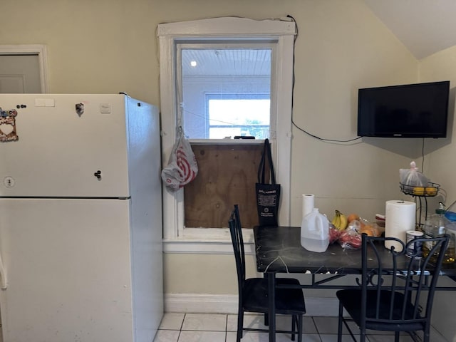 4221 N Sawyer Ave, Chicago, IL 60618 - kitchen featuring light tile patterned floors, vaulted ceiling, and freestanding refrigerator