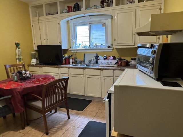 4221 N Sawyer Ave, Chicago, IL 60618 - kitchen featuring a sink, light tile patterned floors, white cabinetry, and under cabinet range hood